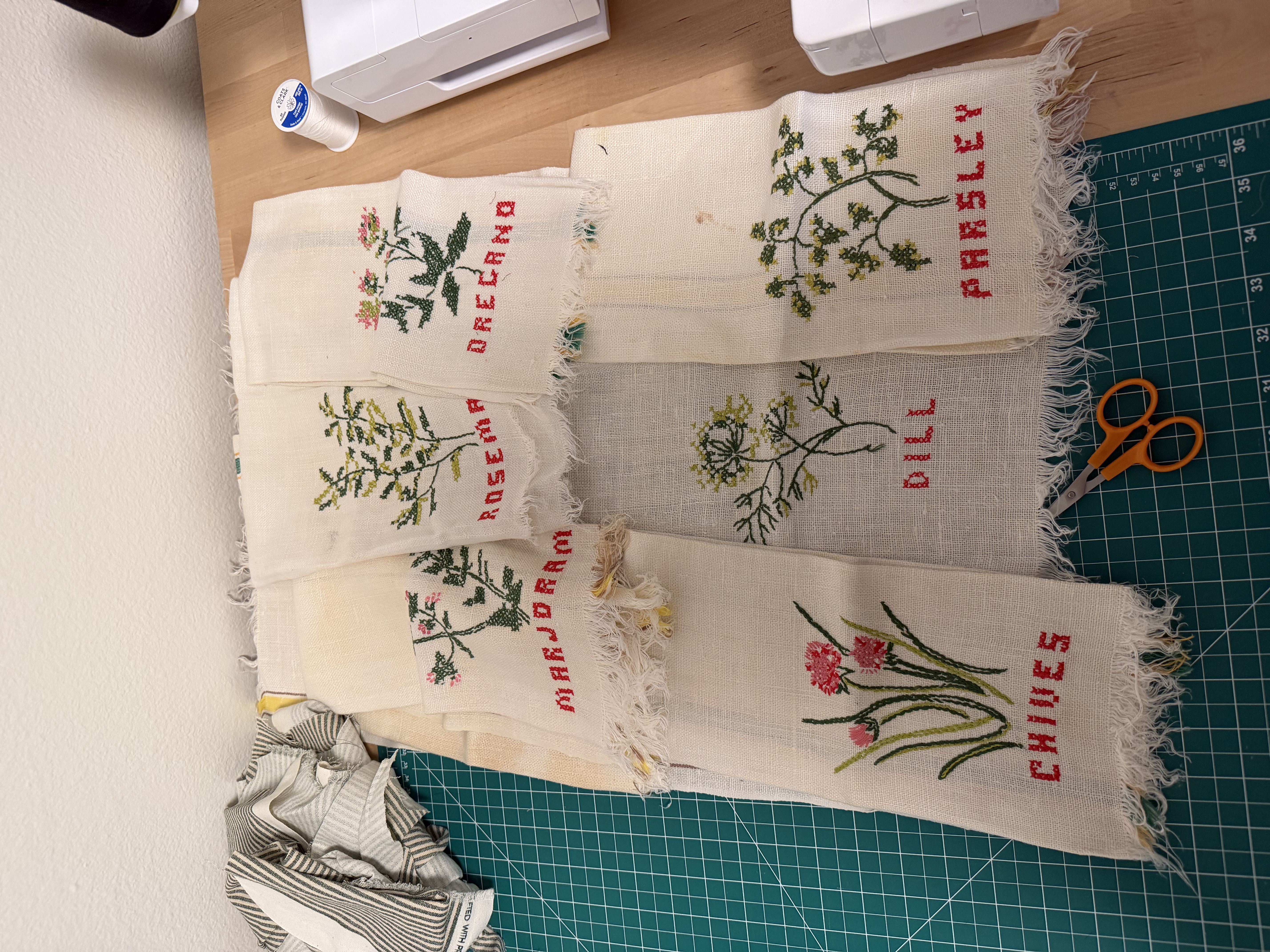 The original stack of vintage linen napkins before cutting, each hand-embroidered with a different herb